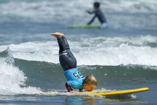 Sebastian Desposato, 9, does a hand stand while surfing during the Challenged Athletes Foundation's Youth Adaptive Surfing Camp in Del Mar on June 28, 2018. Sebastian, who has achondroplasia, the most common form of dwarfism, was working on a few new moves to compete in the Switchfoot BRO-AM. (Photo by K.C. Alfred/San Diego Union-Tribune)