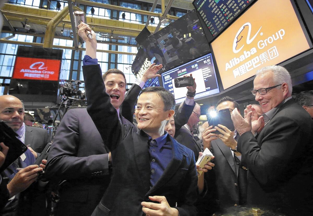 Jack Ma, center, Alibaba’s chairman, smiles Friday while touring the New York Stock Exchange. Alibaba was founded in 1999 by a group of 18 people, led by Ma.