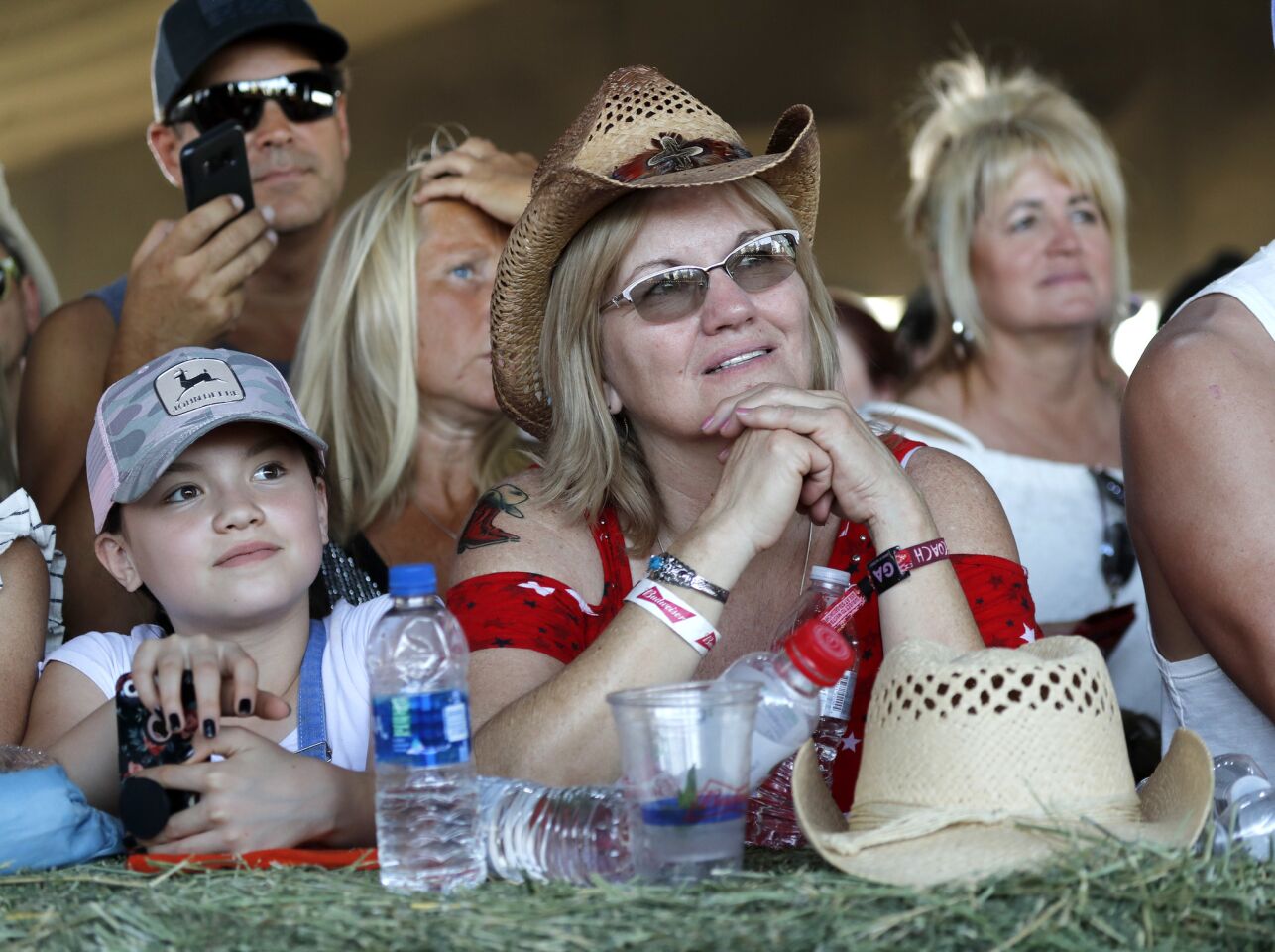 Fans on the front row lean on hay bales at Tanya Tucker's show.