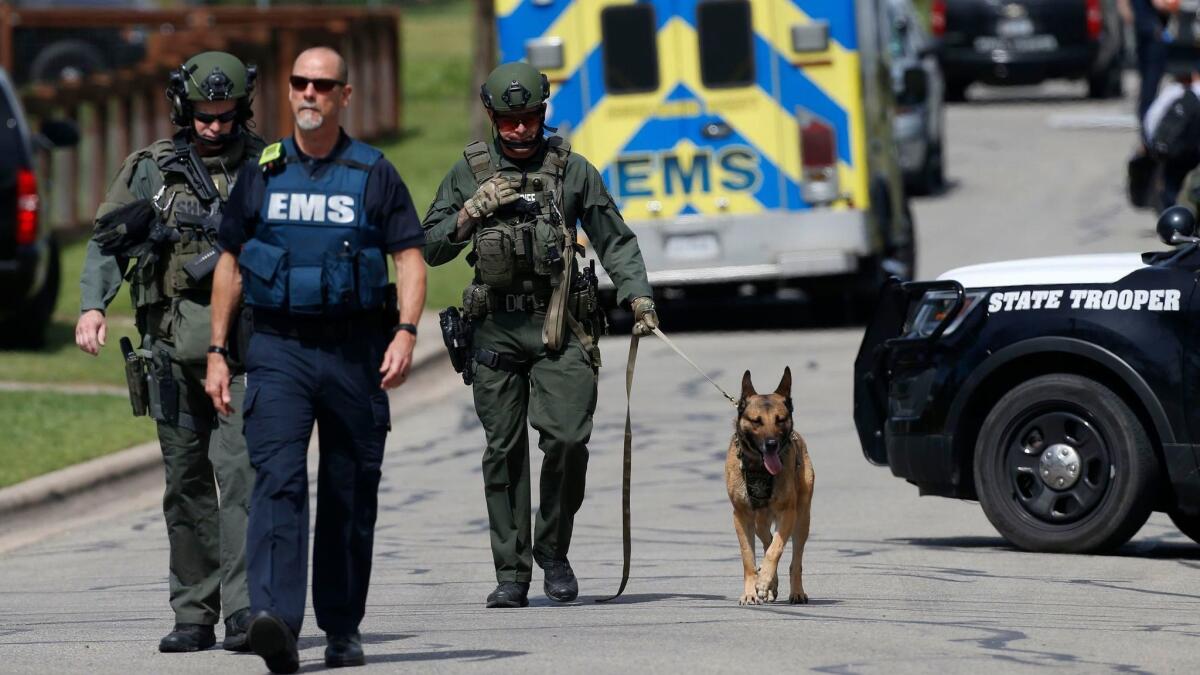 Police walk through a Pflugerville, Texas, neighborhood as the FBI investigates the home of the Austin serial bomber.