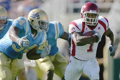 Jerome Harrison of the Washington State Cougars runs as Robert Garcia of UCLA chases him down during their game at the Rose Bowl.