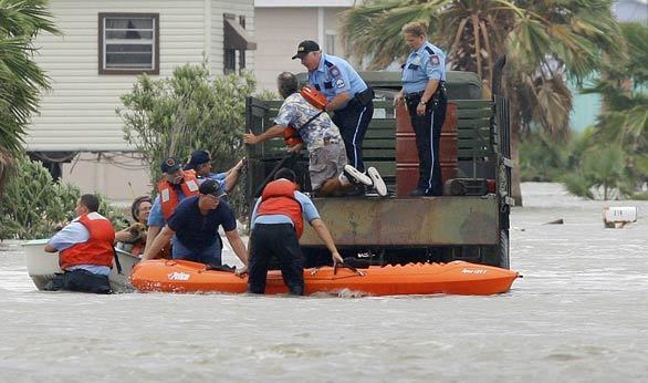 Police and firefighters help evacuate David and Dondi Fields as Hurricane Ike causes flooding in their neighborhood in Surfside Beach, Texas.