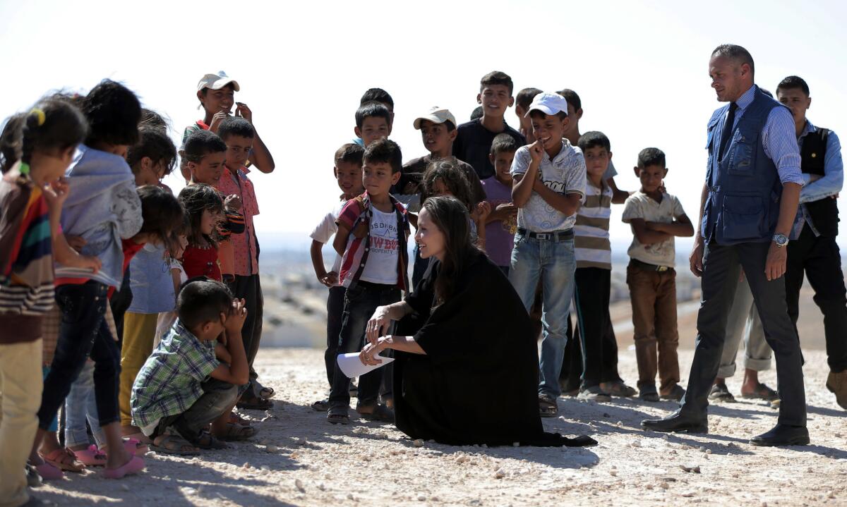 La actriz y enviada especial de la agencia de la ONU para los refugiados Angelina Jolie charla con niños durante una visita a un campo para refugiados sirios en Azraq en el norte de Jordania el viernes 9 de septiembre de 2016. Jolie pidió un mayor apoyo para los refugiados. (Foto AP/Ahmad Alameen)