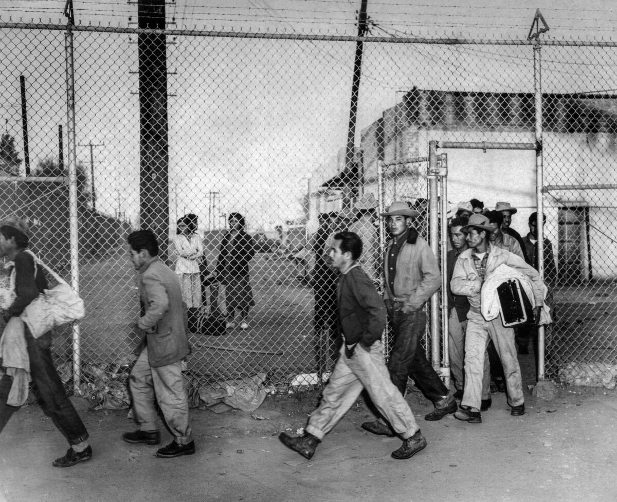 Men walk by a fence