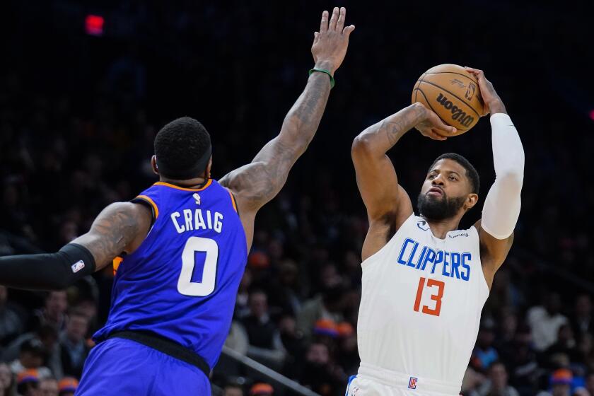 Los Angeles Clippers' Paul George (13) shoots over Phoenix Suns' Torrey Craig (0) during the first half of an NBA basketball game Thursday, Feb. 16, 2023, in Phoenix. (AP Photo/Darryl Webb)