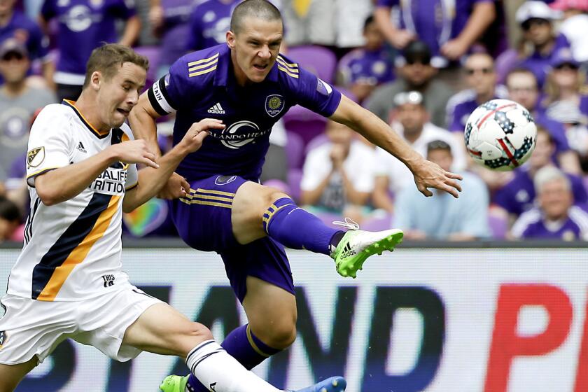 Orlando City's Will Johnson, right, shoots and scores a goal as he gets past Los Angeles Galaxy's Nathan Smith, left, during the first half of an MLS soccer game, Saturday, April 15, 2017, in Orlando, Fla. (AP Photo/John Raoux)