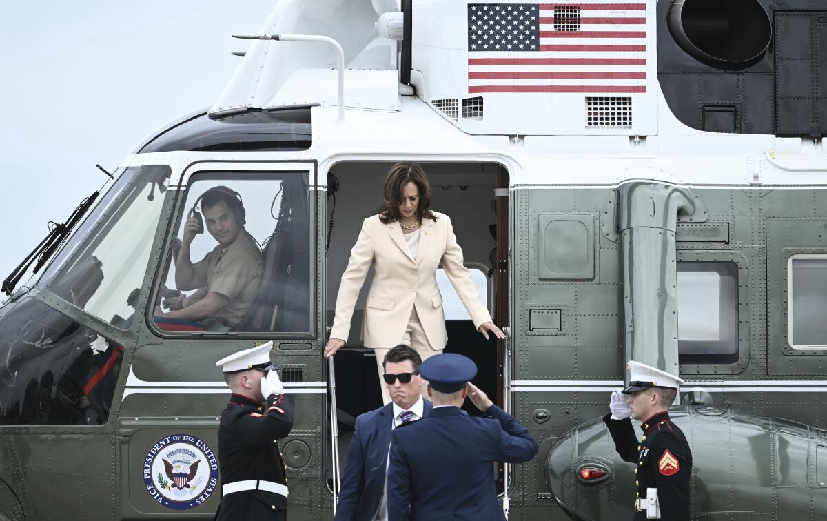 Vice President Kamala Harris steps down from a helicopter. 