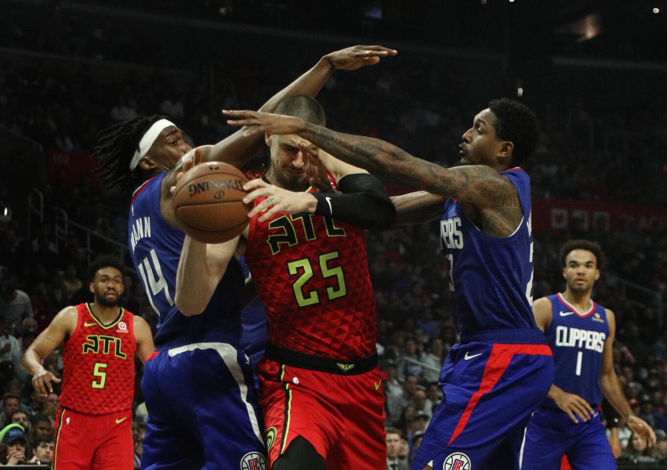 Clippers guard Terance Mann and teammate Lou Williams double-team Atlanta Hawks center Alex Len.