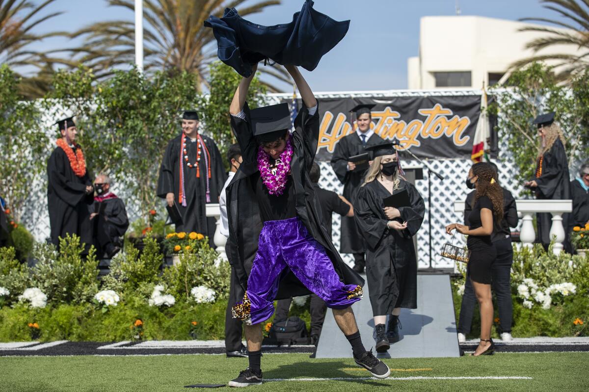 Logan Thobe tears off a pair of rip-away pants during Huntington Beach High School 2021 commencement ceremony.
