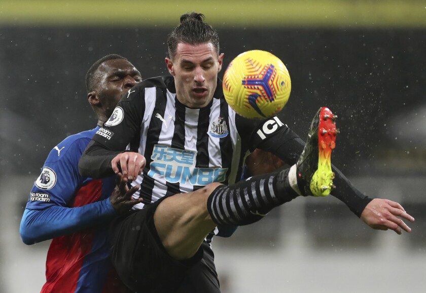 Newcastle United's Fabian Schar, right, and Crystal Palace's Christian Benteke battle for the ball during the English Premier League soccer match between Newcastle United and Crystal Palace at St. James' Park in Newcastle, England, Tuesday, Feb. 2, 2021. (AP Photo/Scott Heppell/Pool)
