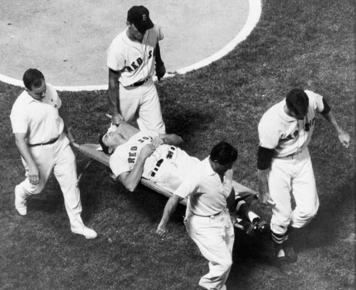Boston Red Sox outfielder Tony Conigliaro is carried off the field on a stretcher by teammates and the trainers.