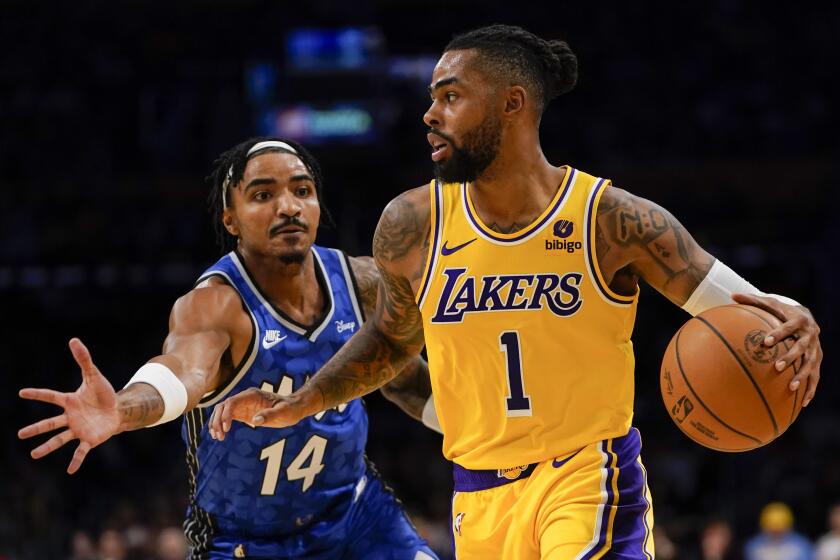 Orlando Magic guard Gary Harris, left, defends as Los Angeles Lakers guard D'Angelo Russell.