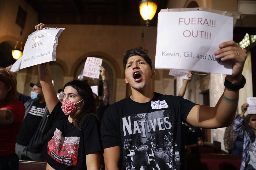 LOS ANGELES, CA - OCTOBER 12, 2022: Esme Torres, left, and Jaime Reyna, join community members in calling for the resignation of Nury Martinez, Kevin de Leon and Gil Cedillo at City Hall Council chambers in downtown Los Angeles on Wednesday, October 12, 2022. (Christina House / Los Angeles Times)