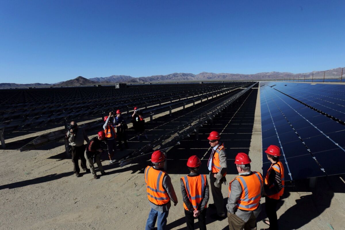 Officials tour a new solar power plant in Riverside County in February. While some politicians want more renewable energy in California, it can be difficult to manage.