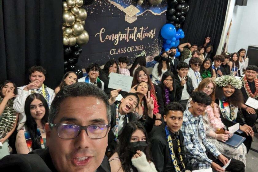Perkins K-8 principal Fernando Hernández takes a selfie with the school's graduating class of 2023.