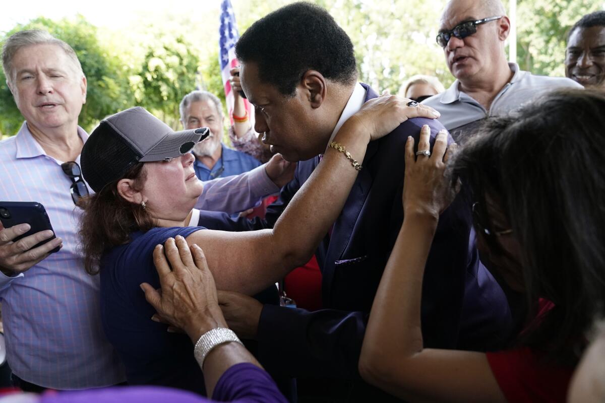 Supporter Paulette Melton hugs gubernatorial candidate Larry Elder at a campaign stop in Norwalk in July.