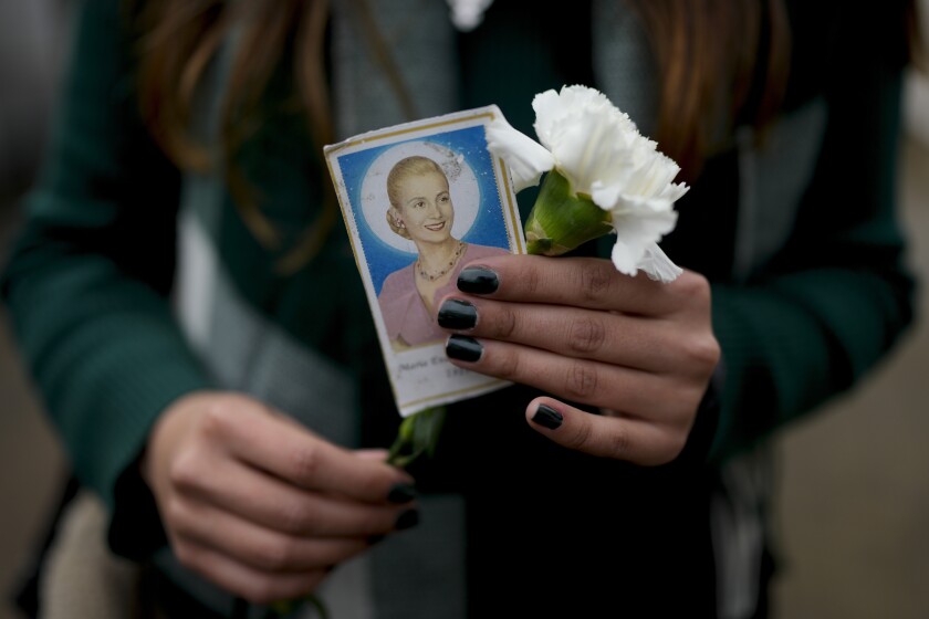 Una mujer sostiene una fotografía de la difunta primera dama de Argentina, María Eva Duarte