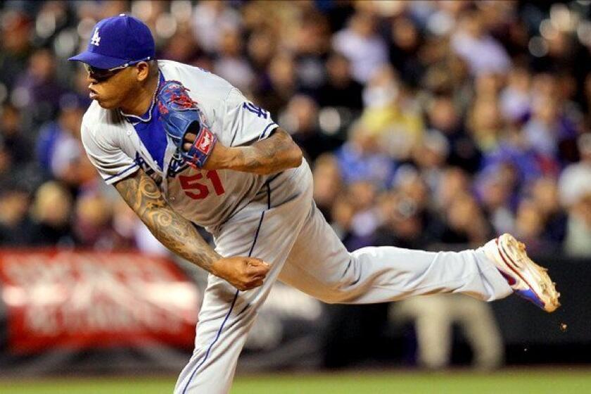 Dodgers reliever Ronald Belisario delivers a pitch against the Colorado Rockies at Coors Field last month.