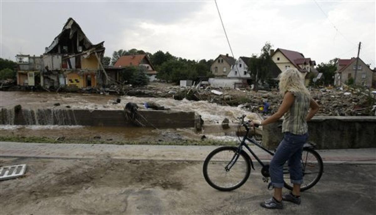 A resident overlooks the damage after a flash floods hit the town of Bogatynia, Poland, Sunday, Aug. 8, 2010. The flooding has struck an area near the borders of Poland, Germany and the Czech Republic. (AP Photo/Petr David Josek)