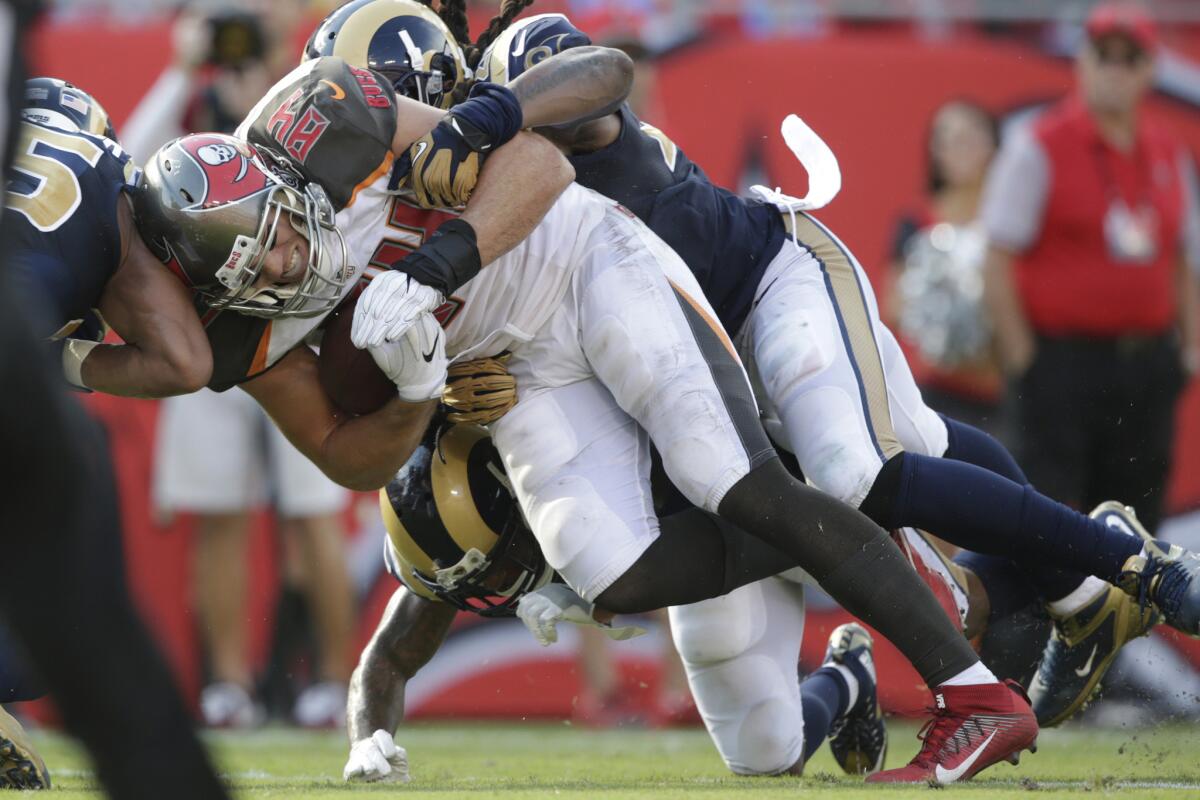 Rams defenders tackle Buccaneers tight end Cameron Brate during third quarter action at Raymond James Stadium.