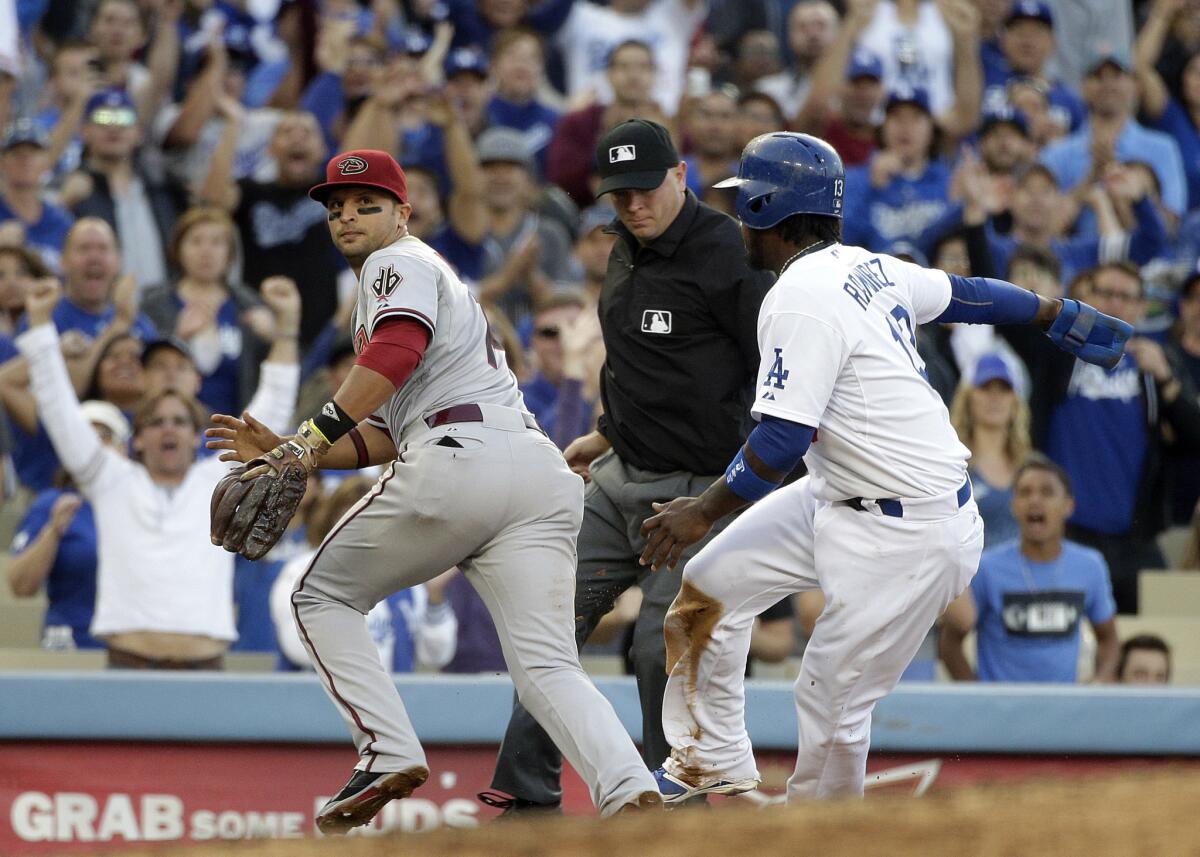 Hanley Ramirez, right, safely takes third base as Arizona's Martin Prado goes after the ball during the fifth inning of the Dodgers' 8-6 victory Saturday at Dodger Stadium.