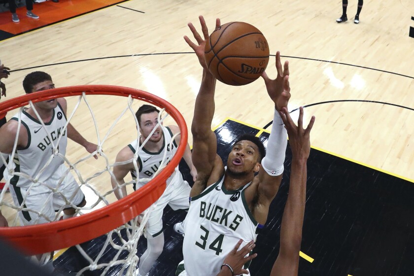 Milwaukee Bucks forward Giannis Antetokounmpo (34) reaches for the ball during the first half against the Phoenix Suns in Game 5 of basketball's NBA Finals, Saturday, July 17, 2021, in Phoenix. (Mark J. Rebilas/Pool Photo via AP)