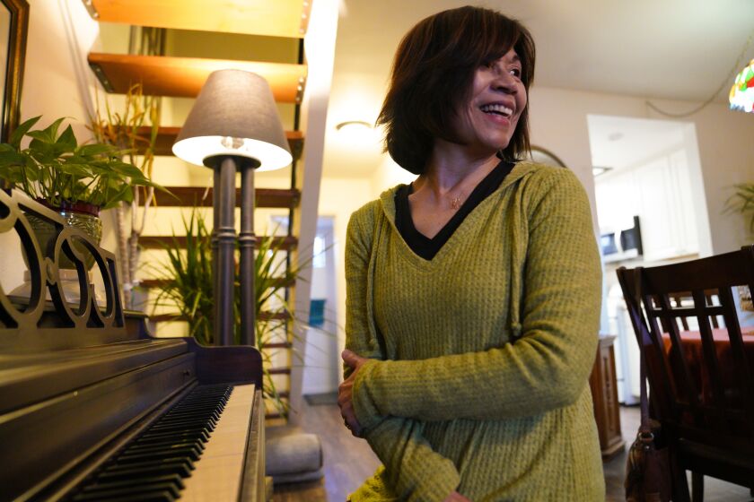 SANTEE, CALIFORNIA -JANUARY 22, 2020 At her home in Santee, Carmen Kcomt relaxes playing the piano after a day at the office. Kcomt to the U.S. in the early 2000s fro Peru. Back at home she worked as a judge who presided in a paternity case involving the then-president and was facing threats and attacks. She arrived in the U.S. with tourist visa and then applied for asylum to stay. (Nelvin C. Cepeda / The San Diego Union-Tribune)