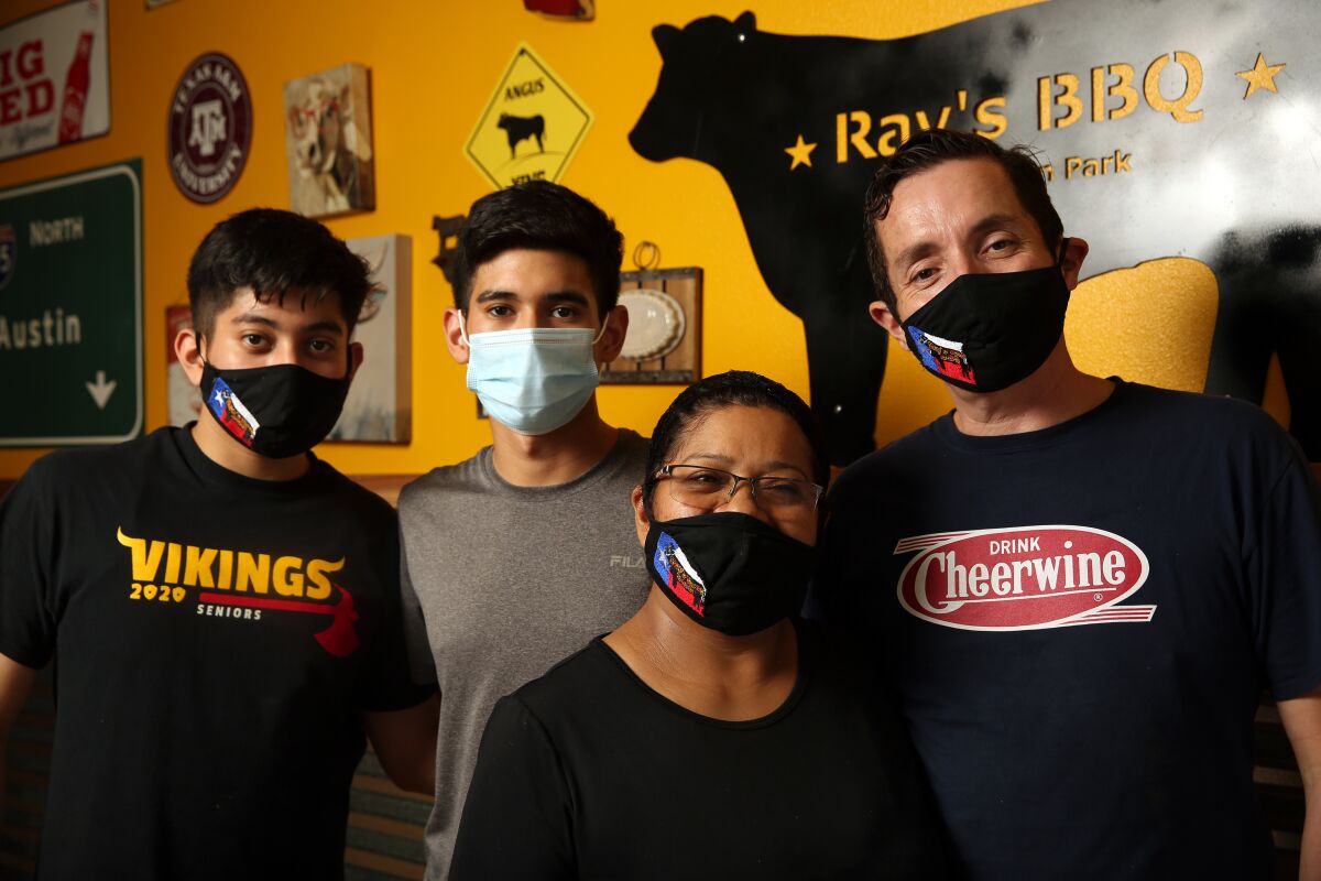 Raul, Sebastian, Anabell and Ray Ramirez, fully masked, pose for a portrait inside Ray's Texas BBQ on July 21, 2020.
