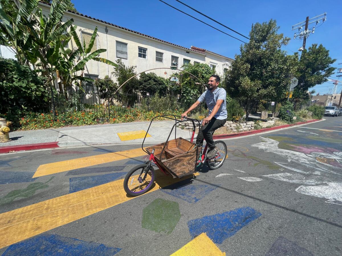 Jimmy Lizama of Koreatown rides one of his recycled cargo bikes on a city street.
