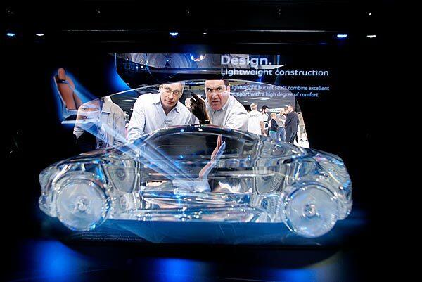 Visitors watch a high-tech presentation on the Audi e-tron concept car. The 10-day Los Angeles Auto Show opened to the public Friday.