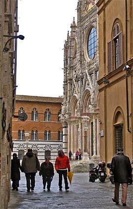 The west façade of Siena's Duomo, in the background at right, is a Gothic structure that was designed chiefly by Nicola Pisano and his son Giovanni.
