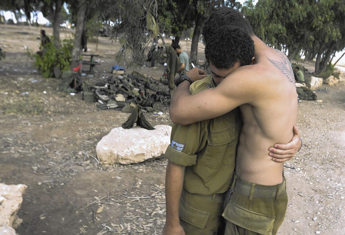An Israeli infantry soldier hugs a colleague after leaving the Gaza Strip.