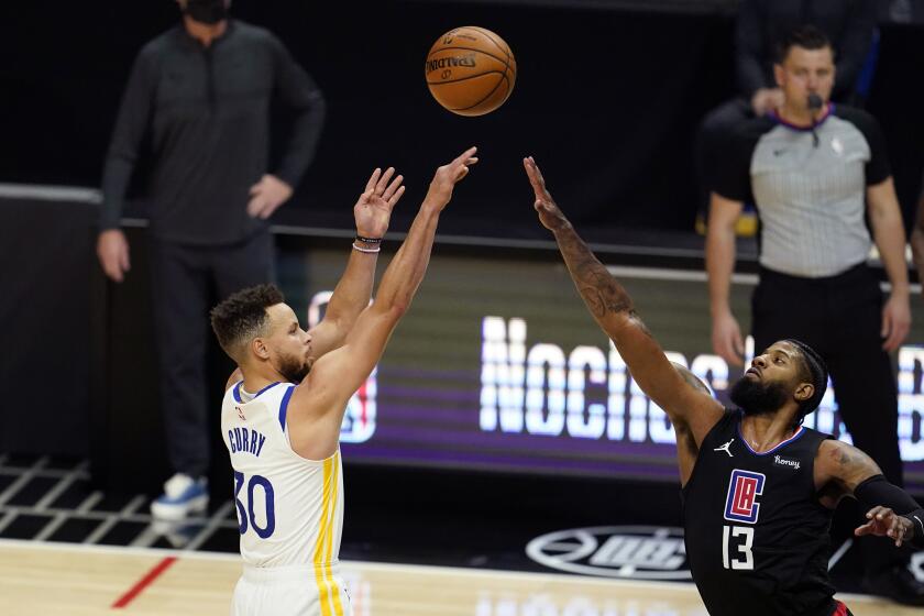 Golden State Warriors guard Stephen Curry, left, shoots over Los Angeles Clippers guard Paul George during the first half of an NBA basketball game Thursday, March 11, 2021, in Los Angeles. (AP Photo/Marcio Jose Sanchez)