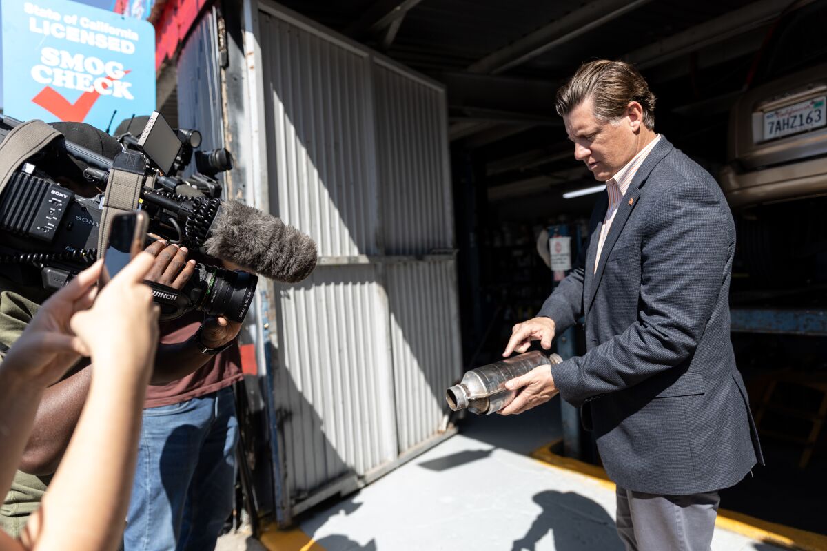 State Sen. Brian Jones, R-Santee, shows a catalytic converter to media at Barrio Auto Service in Sherman Heights