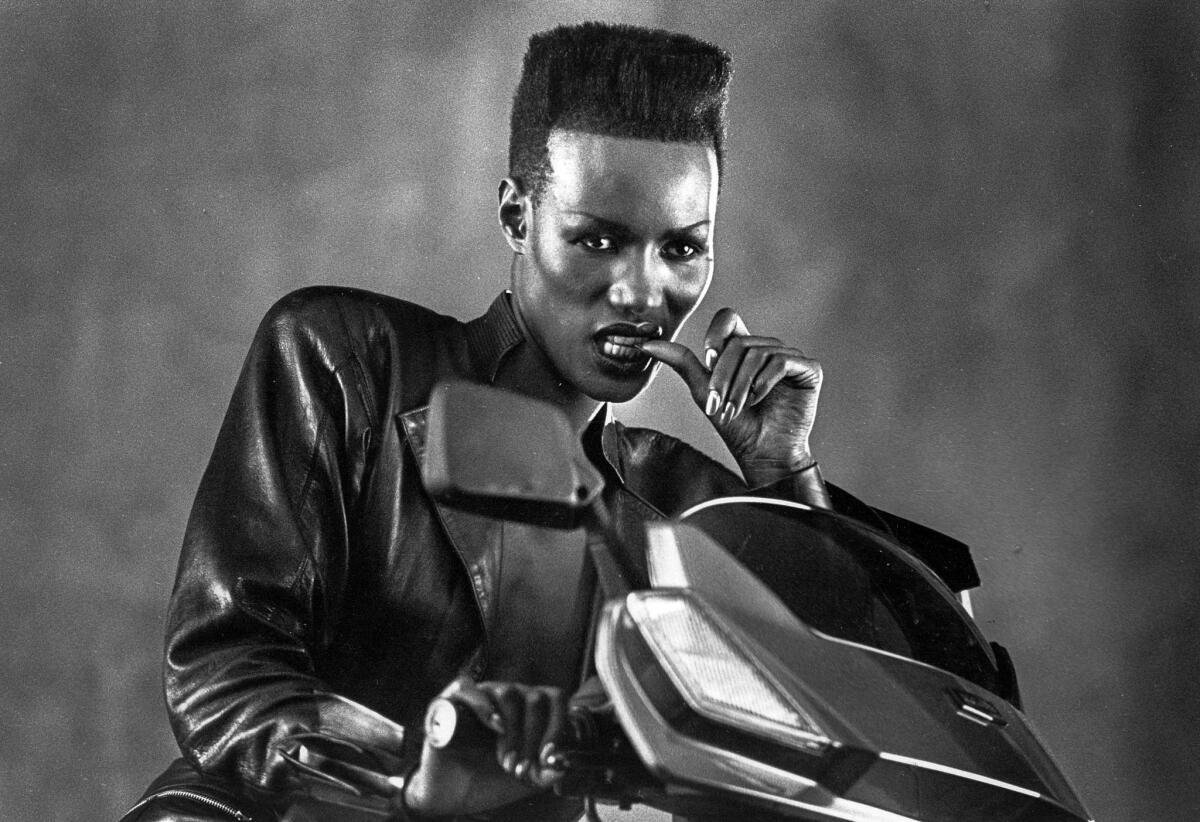 1985: Grace Jones poses for Los Angeles Times staff photographer Larry Davis during a break in the shooting of a Honda motor scooter commercial.
