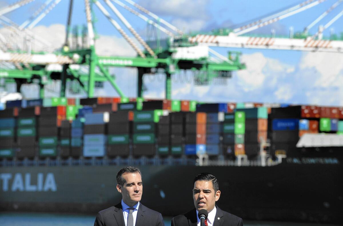 L.A. Mayor Eric Garcetti, left, and Long Beach Mayor Robert Garcia appear at a news conference Monday in San Pedro to celebrate the tentative deal between shipping companies and a union representing port workers.