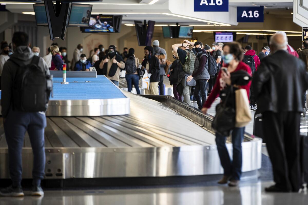 Viajeros esperan su equipaje en el aeropuerto Dallas/Fort Worth.