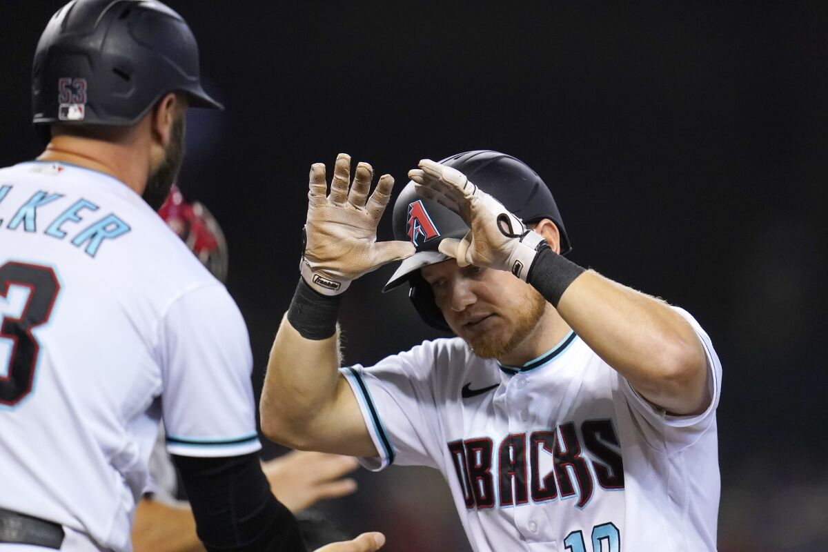 Arizona Diamondbacks' Josh VanMeter, right, celebrates his two-run home run against the Philadelphia Phillies with Christian Walker during the sixth inning of a baseball game Tuesday, Aug. 17, 2021, in Phoenix. (AP Photo/Ross D. Franklin)