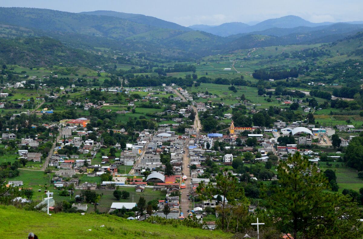 A view from above of a small town with mountains in the background