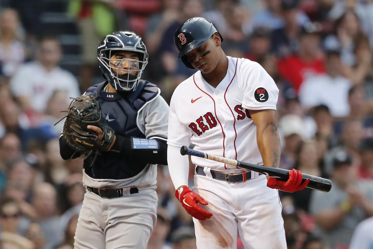 Boston Red Sox's Rafael Devers, right, reacts after striking out swinging, next to New York Yankees catcher Jose Trevino during the first inning of a baseball game, Friday, July 8, 2022, in Boston. (AP Photo/Michael Dwyer)