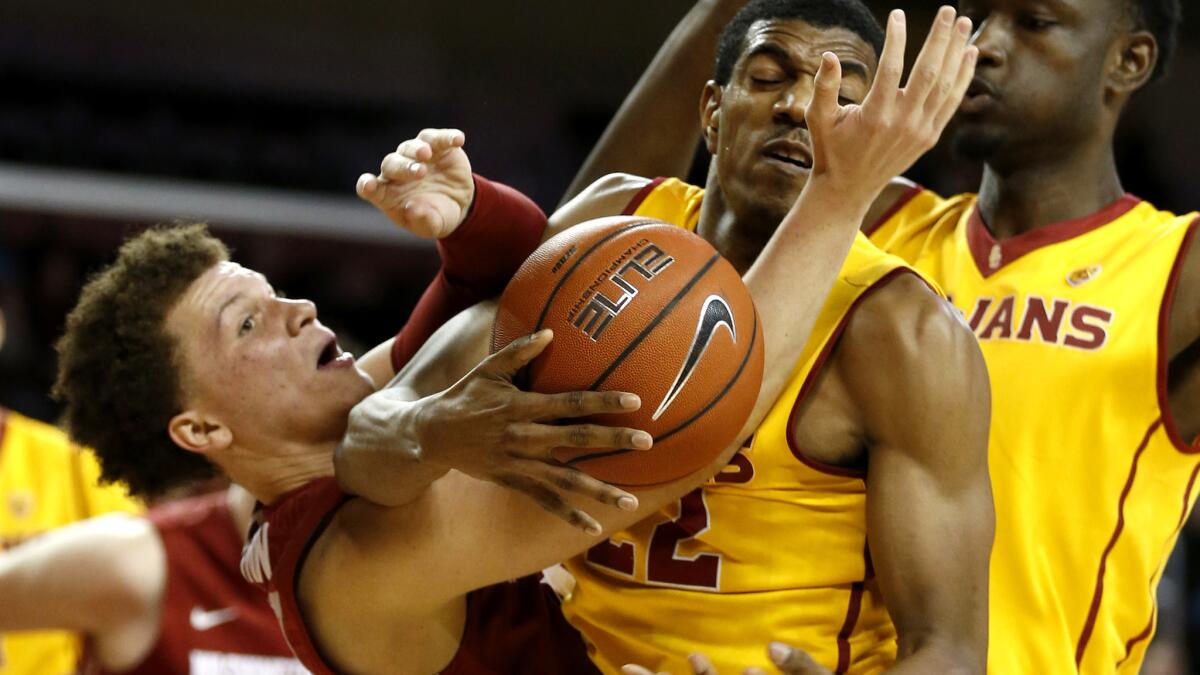 USC guard De'Anthony Melton, center, battles for a rebound against Washington State guard Malachi Flynn during the second half Wednesday.