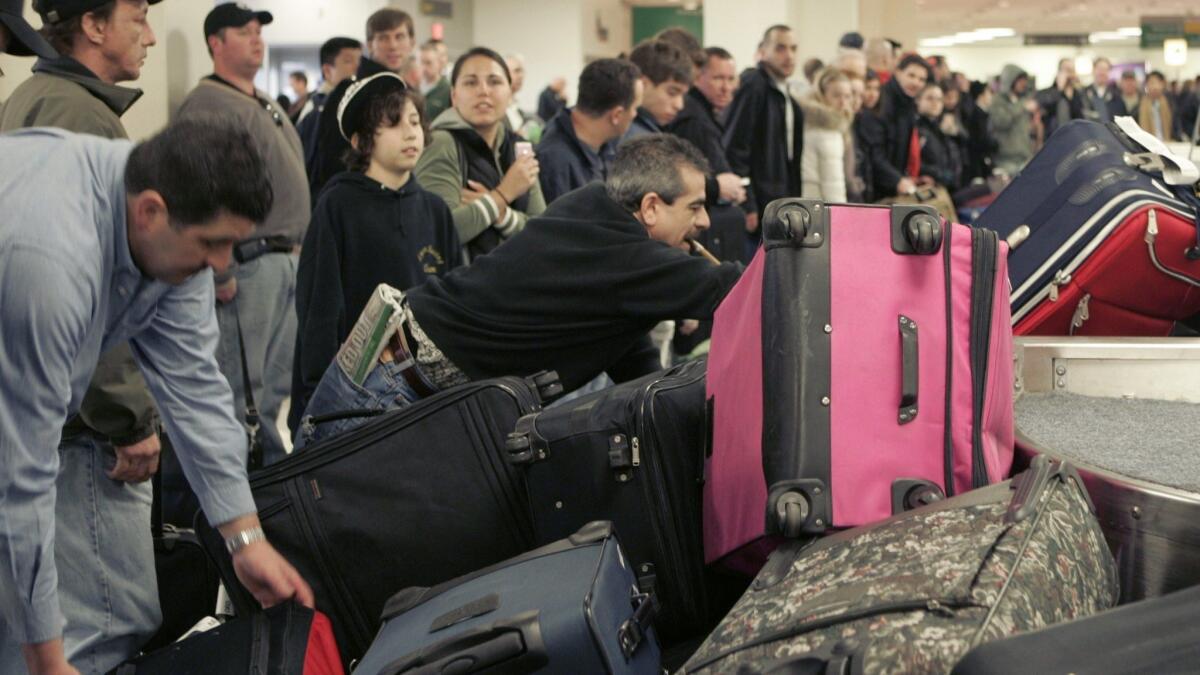 Passengers grab their suitcases on a carousel at Newark Liberty International Airport in New Jersey.