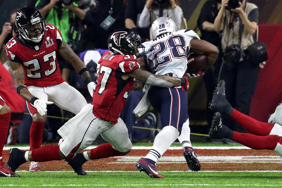 Patriots running back James White breaks a tackle attempt by Falcons defensive back Ricardo Allen to score the game-winning touchdown from two yards in overtime in Super Bowl LI.