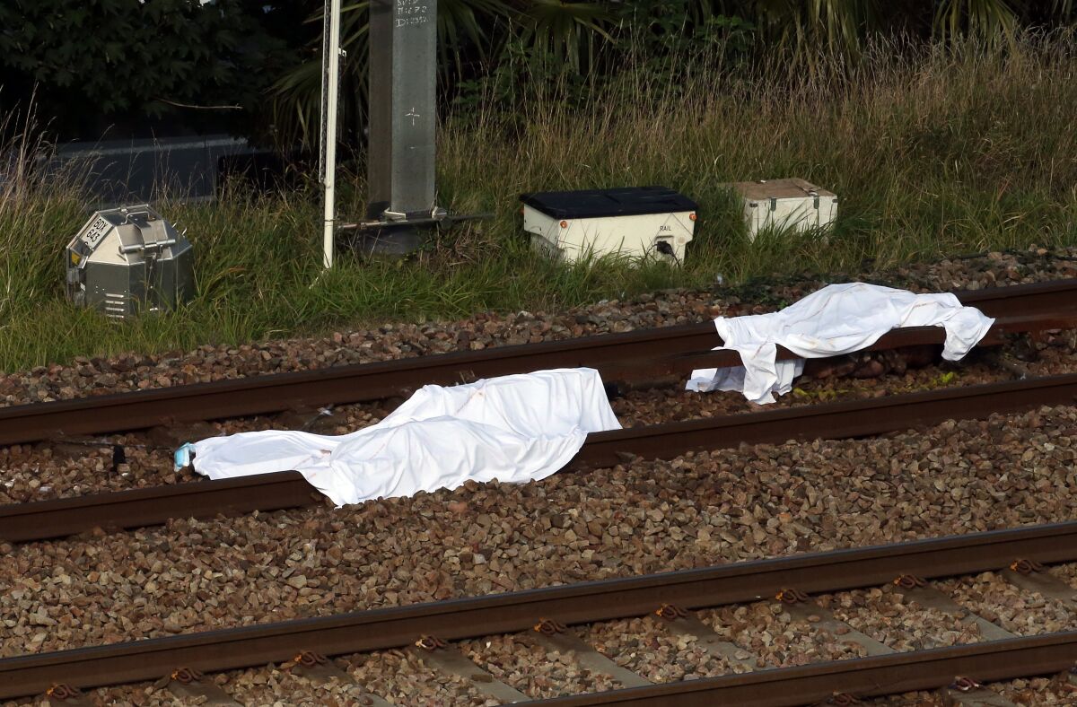 Bodies are covered with blankets after a train accident in Ciboure, near Saint Jean de Luz, southwestern France, Tuesday, Oct.12, 2021. A train hit and killed three people and seriously injured another person in southwestern France on Tuesday morning. A local mayor said the victims were thought to be migrants who were resting on the tracks. (AP Photo/Bob Edme)