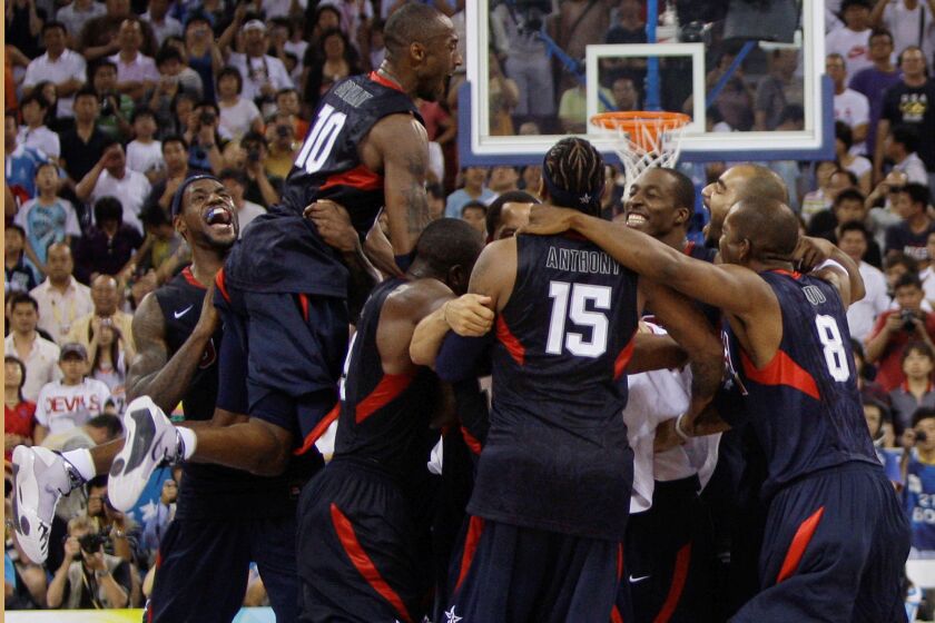 FILE - USA's Kobe Bryant (10) leaps on top of teammates as they celebrate after beating Spain 118-107 in the men's gold medal basketball game at the Beijing 2008 Olympics in Beijing on Aug. 24, 2008. A documentary on the 2008 U.S. men’s basketball team known as the “Redeem Team,” with executive producers including Lebron James and Dwayne Wade, will premiere on Netflix in October. (AP Photo/Dusan Vranic, File)
