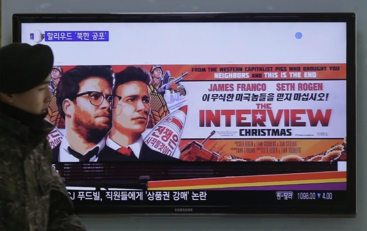 At a train station in Seoul, a poster of the film "The Interview" is shown during a TV newscast.