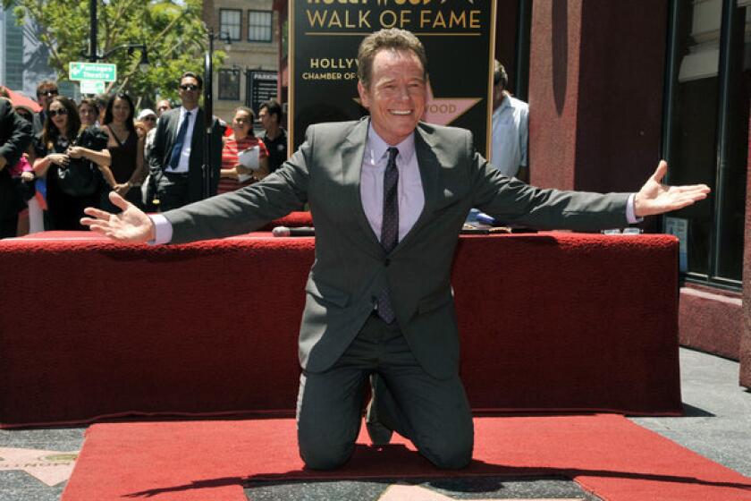 Actor Bryan Cranston poses atop his new star on the Hollywood Walk of Fame...wearing more than his underwear.