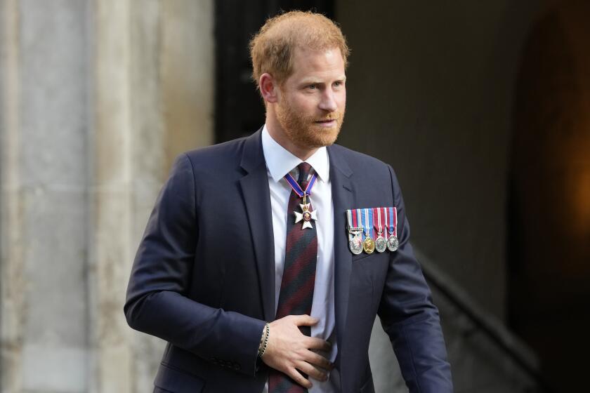 Prince Harry wears a suit decorated with four medals