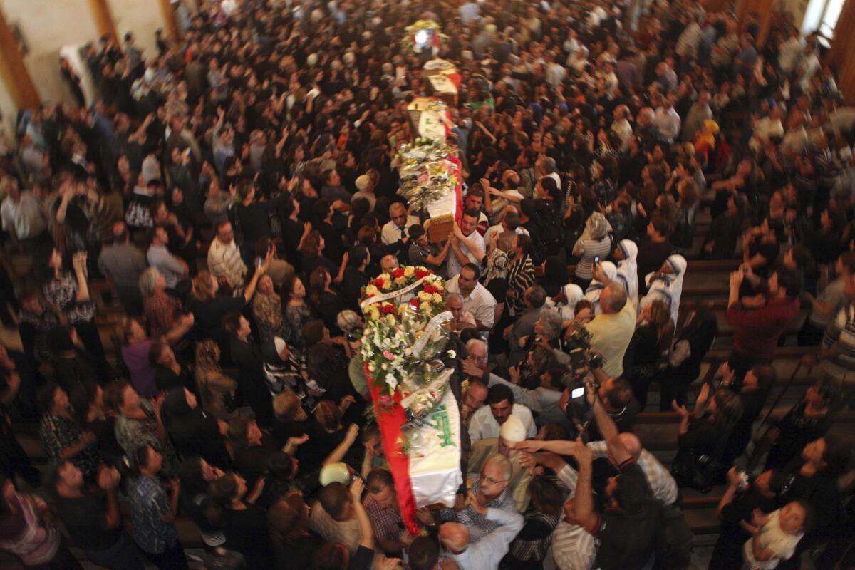 File - In this Tuesday Nov. 2, 2010 file photo, mourners carry the coffins of slain Christians during their funeral in Baghdad, Iraq, who were killed Sunday when gunmen stormed a church during mass and took the entire congregation hostage. The attack, claimed by an al-Qaida-linked organization, was the deadliest recorded against Iraq's Christians since the 2003 U.S.-led invasion unleashed a wave of violence against them. (AP Photo/Khalid Mohammed, File)