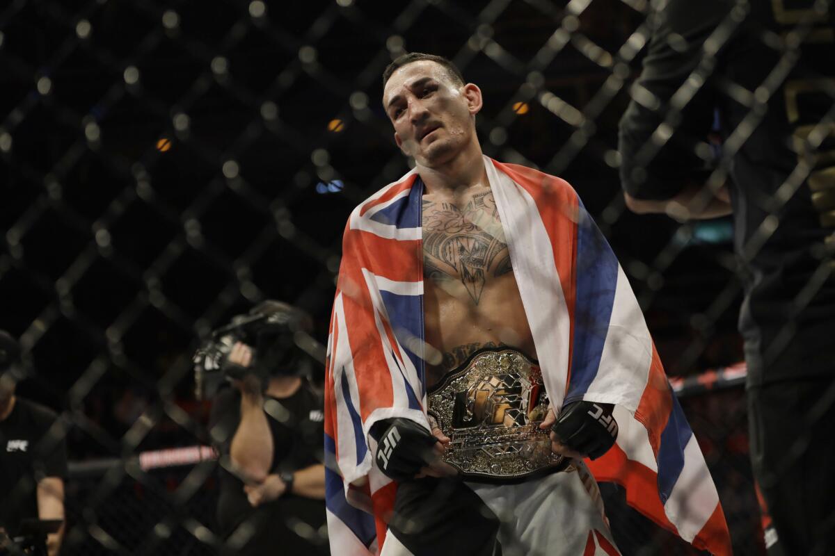 Max Holloway wears the featherweight title belt after defeating former champion Jose Aldo at UFC 212.